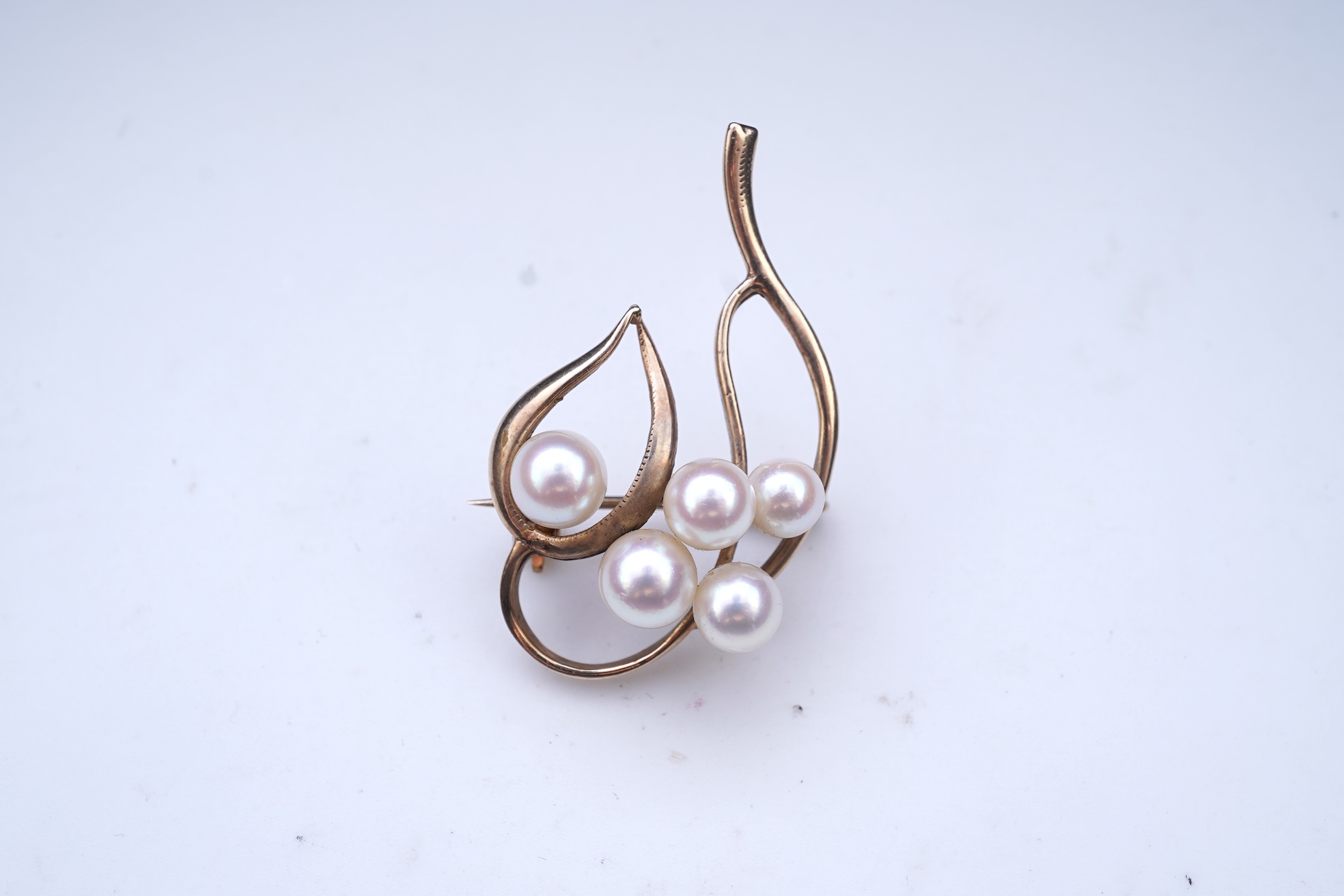 A group of cultured pearl jewels, comprising: two pairs of cultured pearl drop earrings, longest 3cm, mounted in gold; and two cultured pearl brooches mounted in 9ct gold, longest 4.1cm, British hallmarks, combined gross